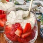 Strawberries and cream in glass with gold spoon