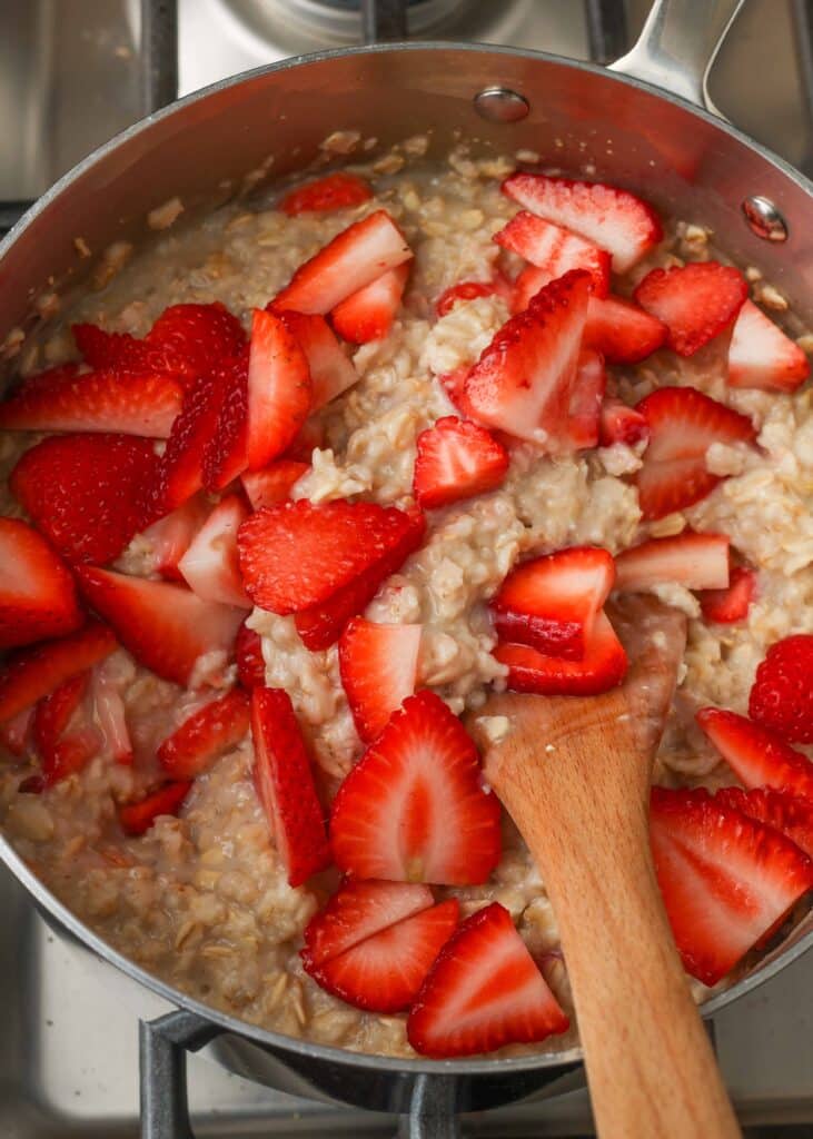 oatmeal with fresh strawberries in pan on stove