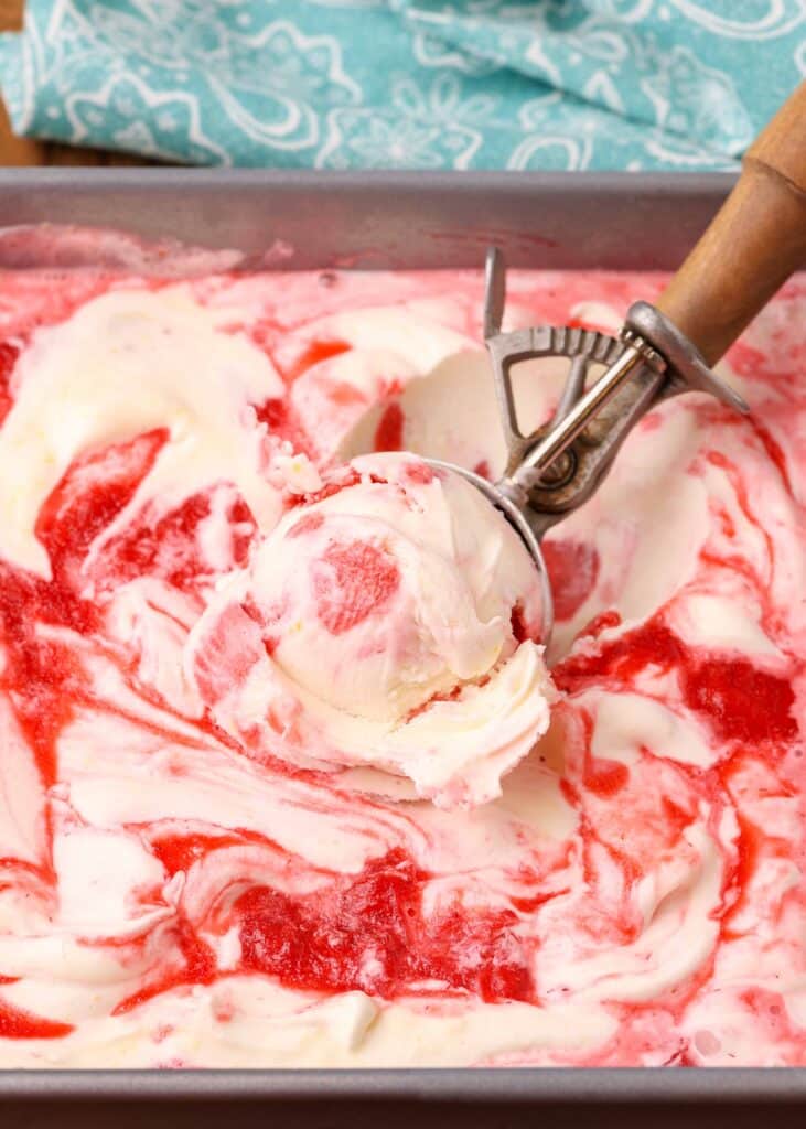 strawberry swirled cheesecake ice cream in a scoop