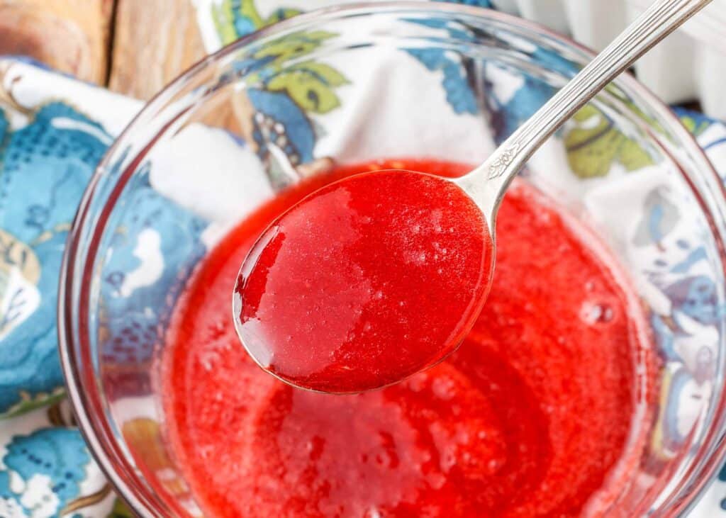 salsa de fresa casera en un bol con una cuchara