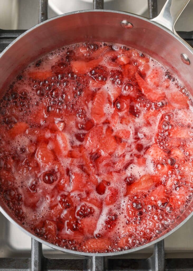 Fresas hirviendo en agua para liberar jugos naturales.