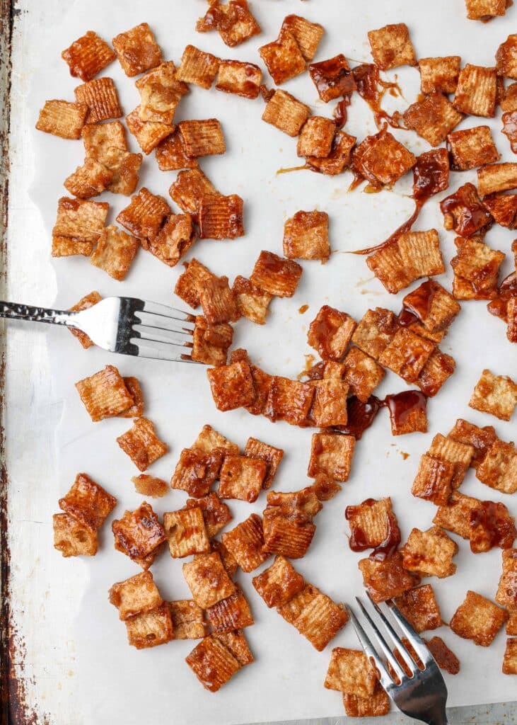 Using two forks, separate each piece of Cinnamon Toast Crunch cereal on a piece of parchment paper