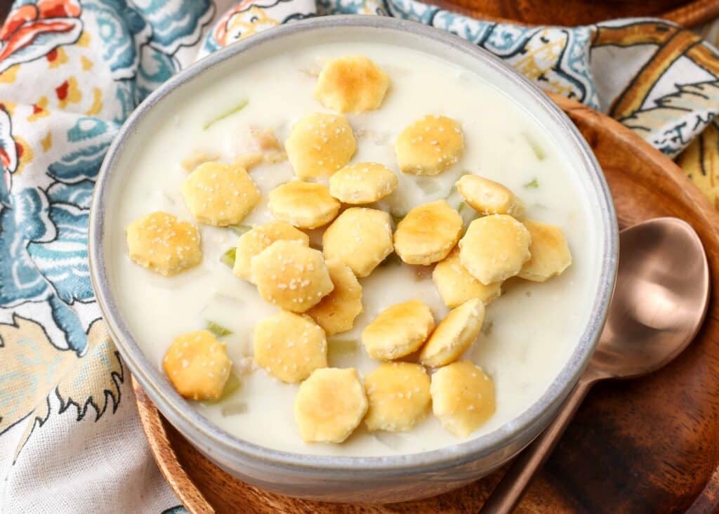 clam chowder with oyster crackers in pottery bowl on floral napkin