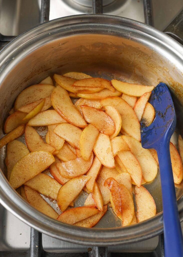 a photo looking into the small metal pan on the stove where the apples have been prepared for the german apple pancake