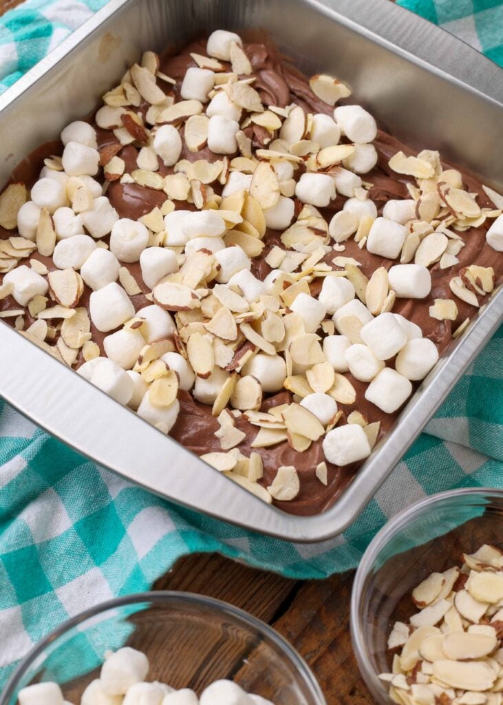 chocolate ice cream with sliced almonds and marshmallows in pan on checkered towel
