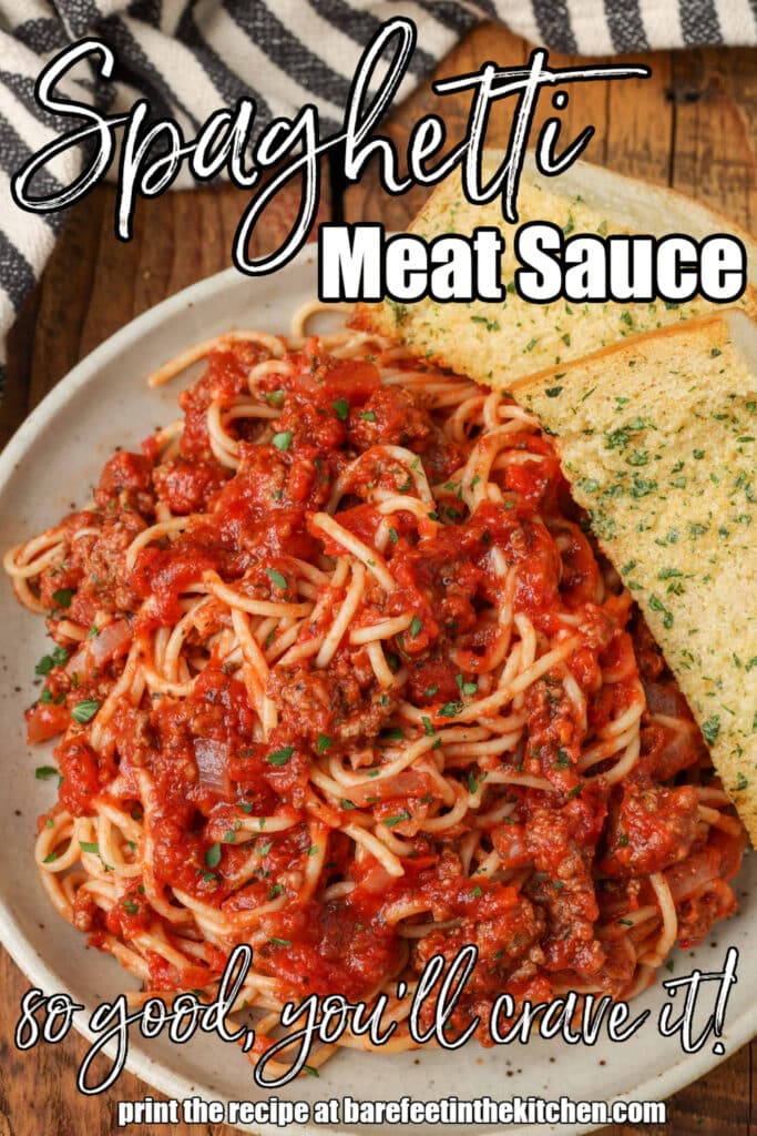 Photo of spaghetti bolognese with garlic bread on a white plate. White text is written on the image. "spaghetti meat sauce"