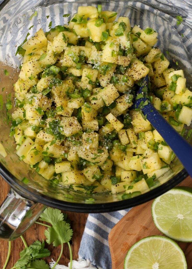 Pineapple, jalapenos, cilantro, green onions, and lime in mixing bowl