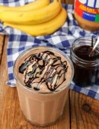 a peanut butter smoothie has been drizzled with chocolate sauce and is ready to drink in this photo