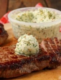 cowboy butter over grilled steak on cutting board