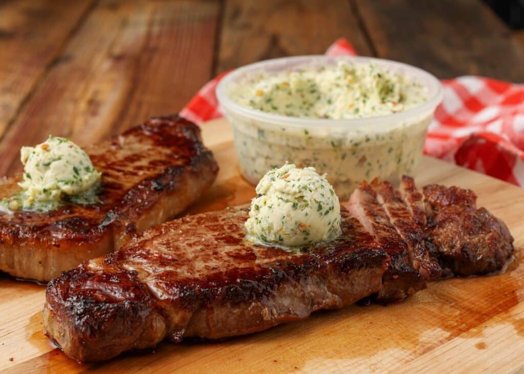 steaks on cutting board with compound butter