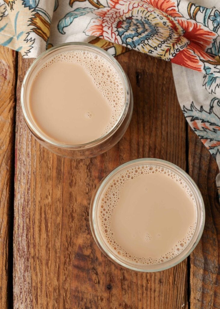 A simple chai recipe to pour into a glass next to a floral napkin