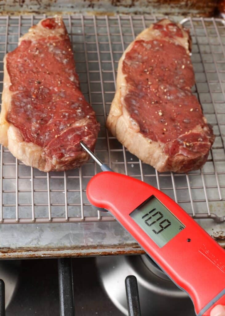 reverse seared steaks taken out of the oven and tested with thermometer