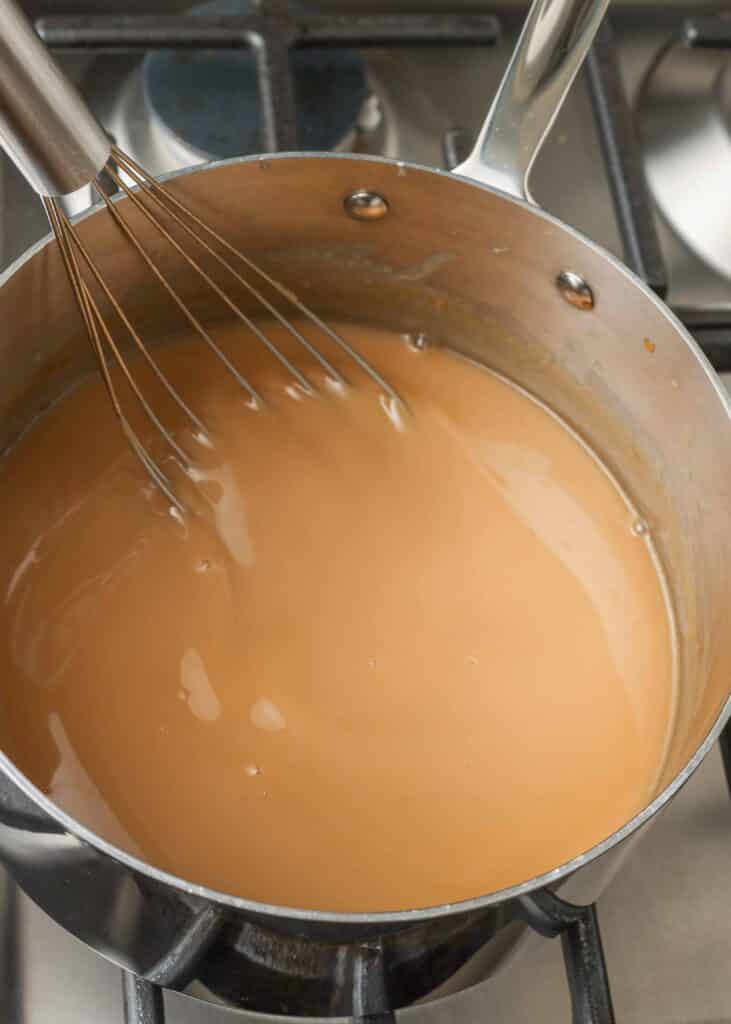 whisking shot of caramel in sauce pan