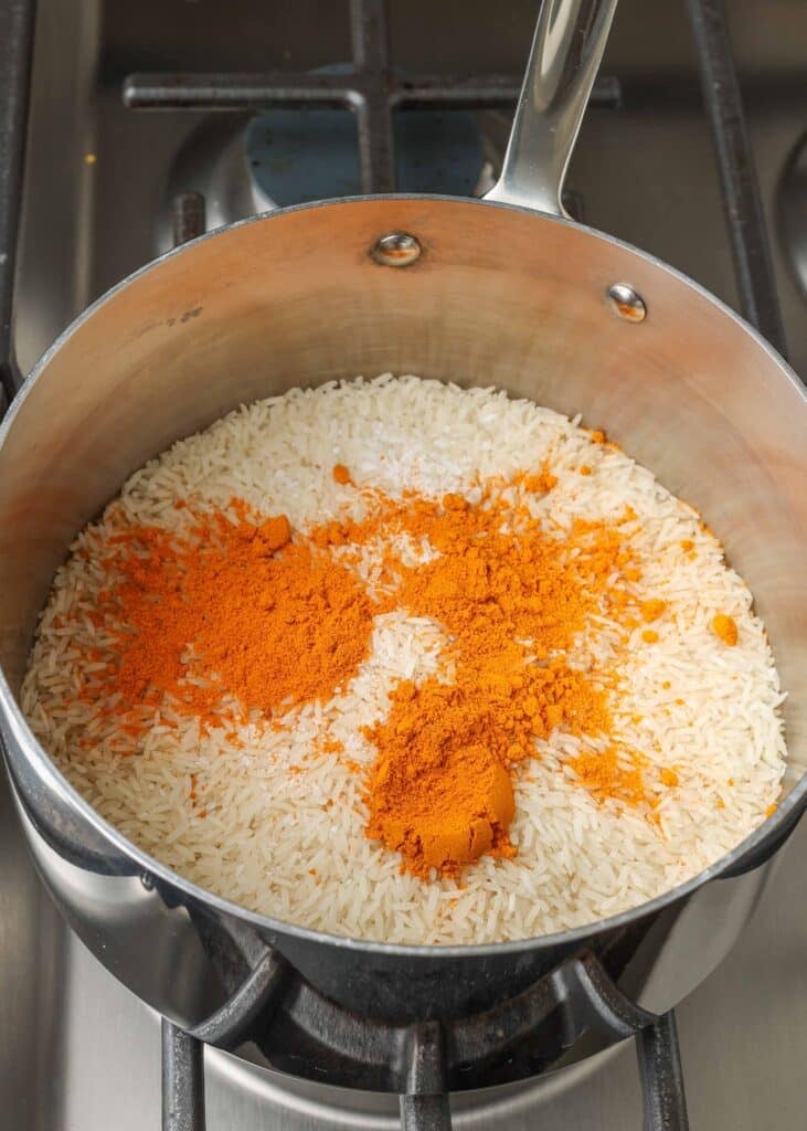 uncooked rice and spices in pan