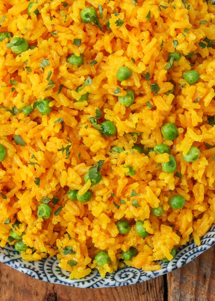 close up photo of turmeric rice with peas