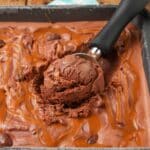 close up of chocolate caramel ice cream with cashew pieces and ice cream scoop