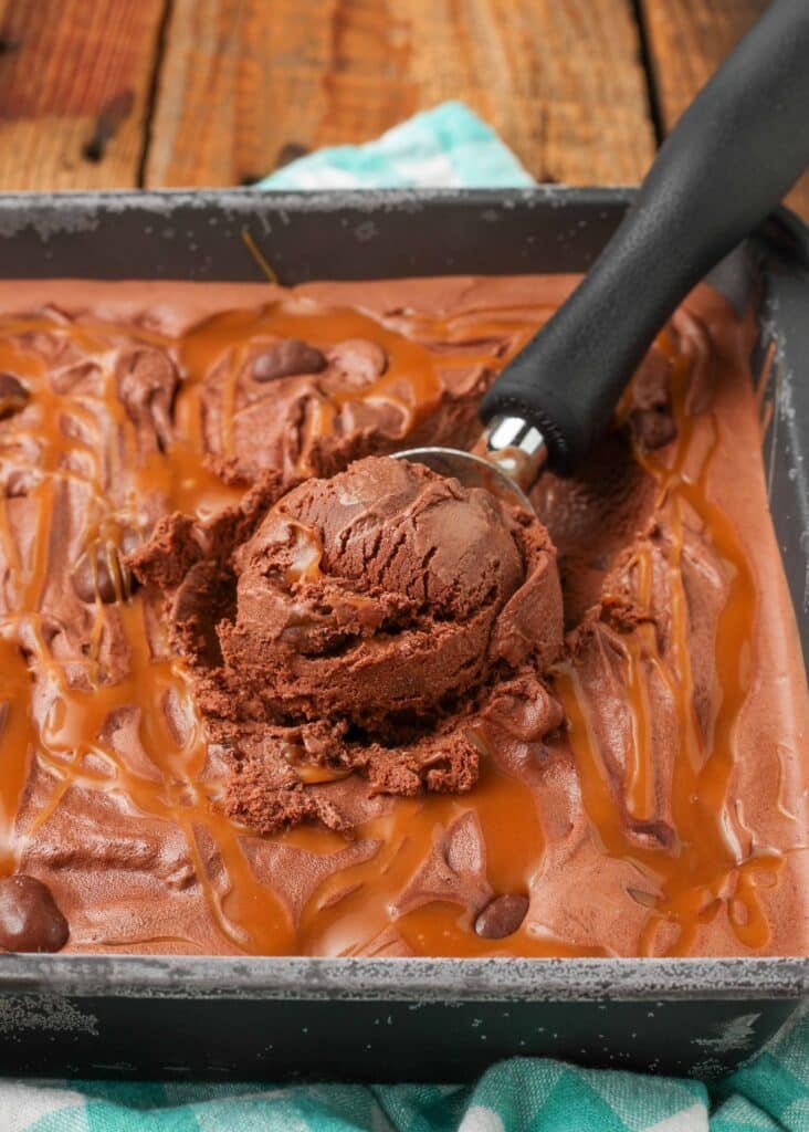 primo piano di gelato al caramello al cioccolato con pezzi di anacardi e pallina di gelato