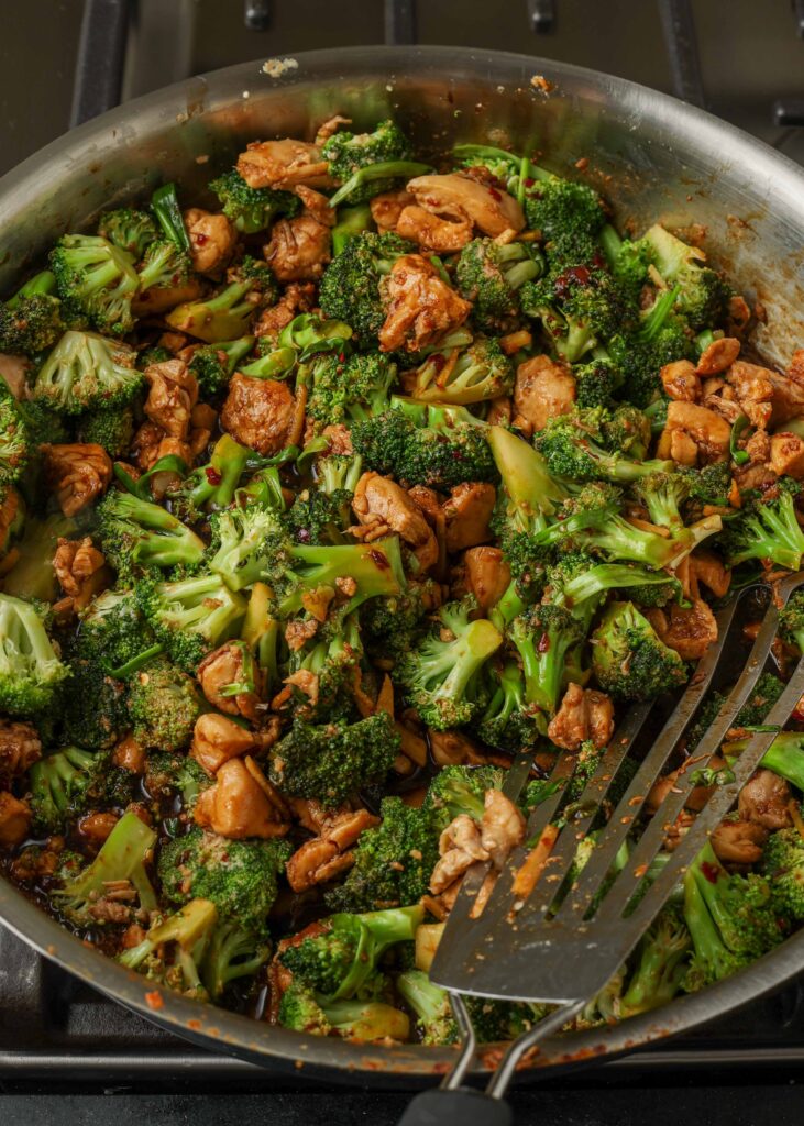 Friggere il pollo con i broccoli in padella con la spatola