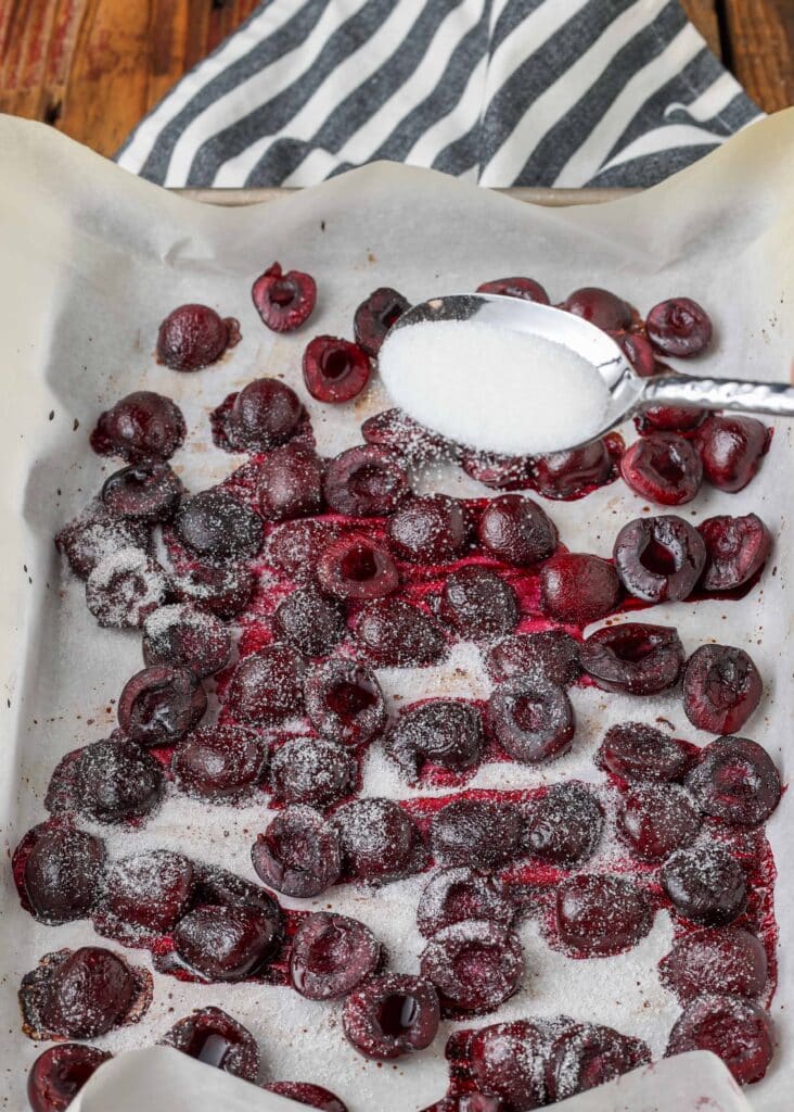 sugar sprinkled over roasted cherries on parchment