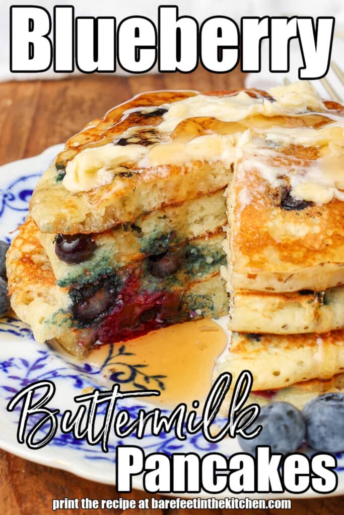 a tropical up shot of the blueberries visible within the pancakes on a undecorous and white plate, with white lettering over the image that reads: "Blueberry Buttermilk Pancakes"