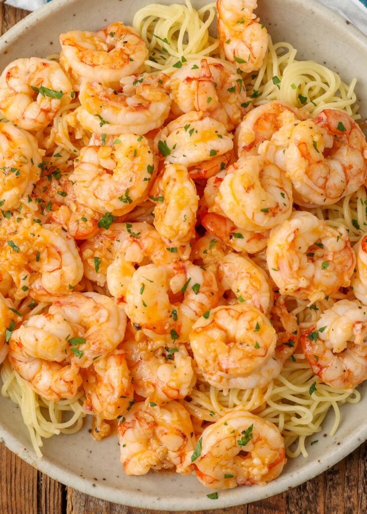 Overhead vertical shot of garlic butter shrimp and buttery pasta, served in a white bowl