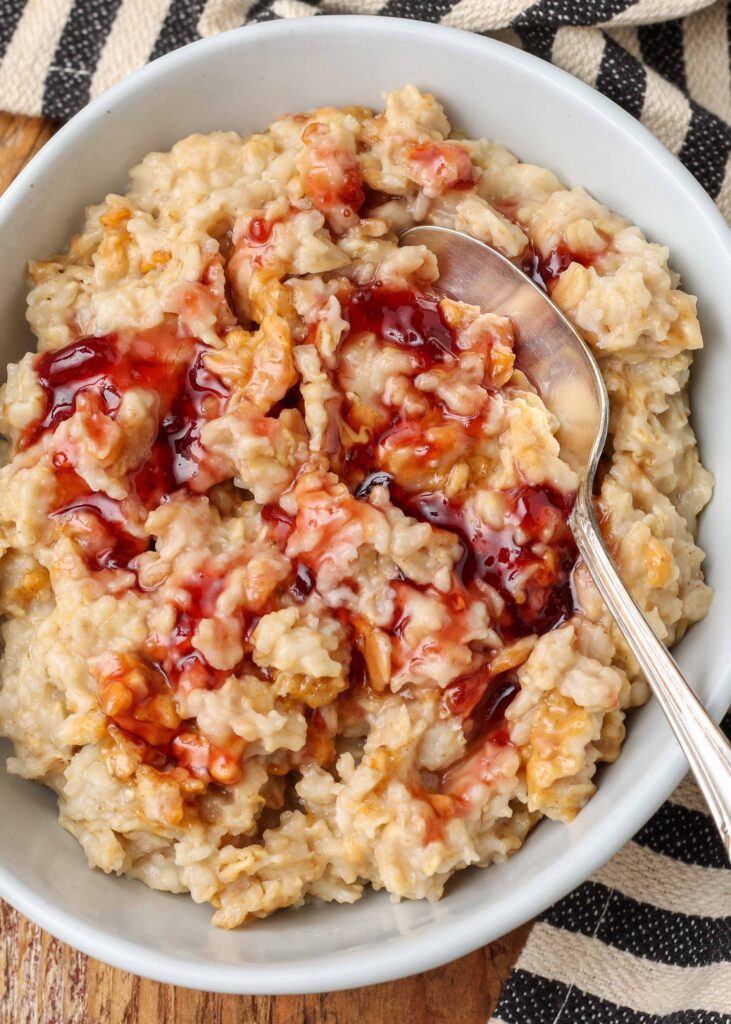 strawberry jam over oatmeal in pottery bowl
