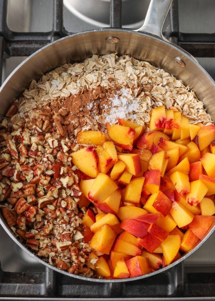 oats, pecans, and peaches in saucepan on stove
