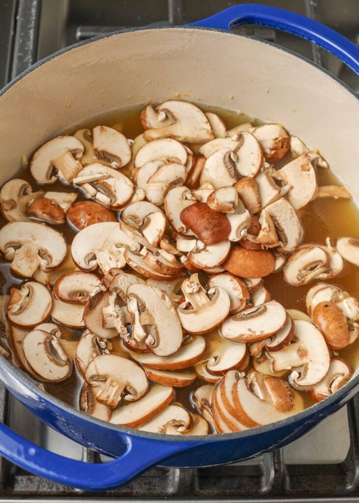 mushrooms and stock simmering in enamel pot