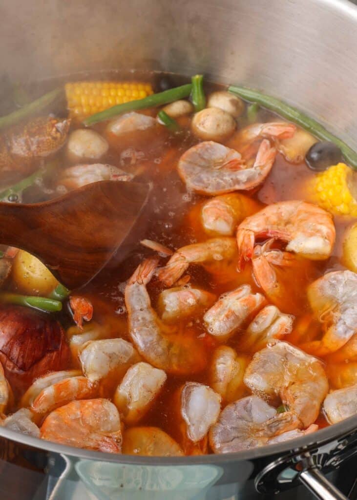 Shrimp, mixed vegetables, and spices boiling in pot