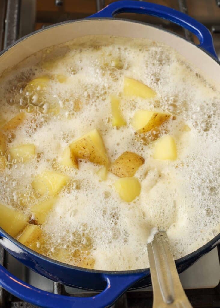 Diced potatoes boiling in a blue pot