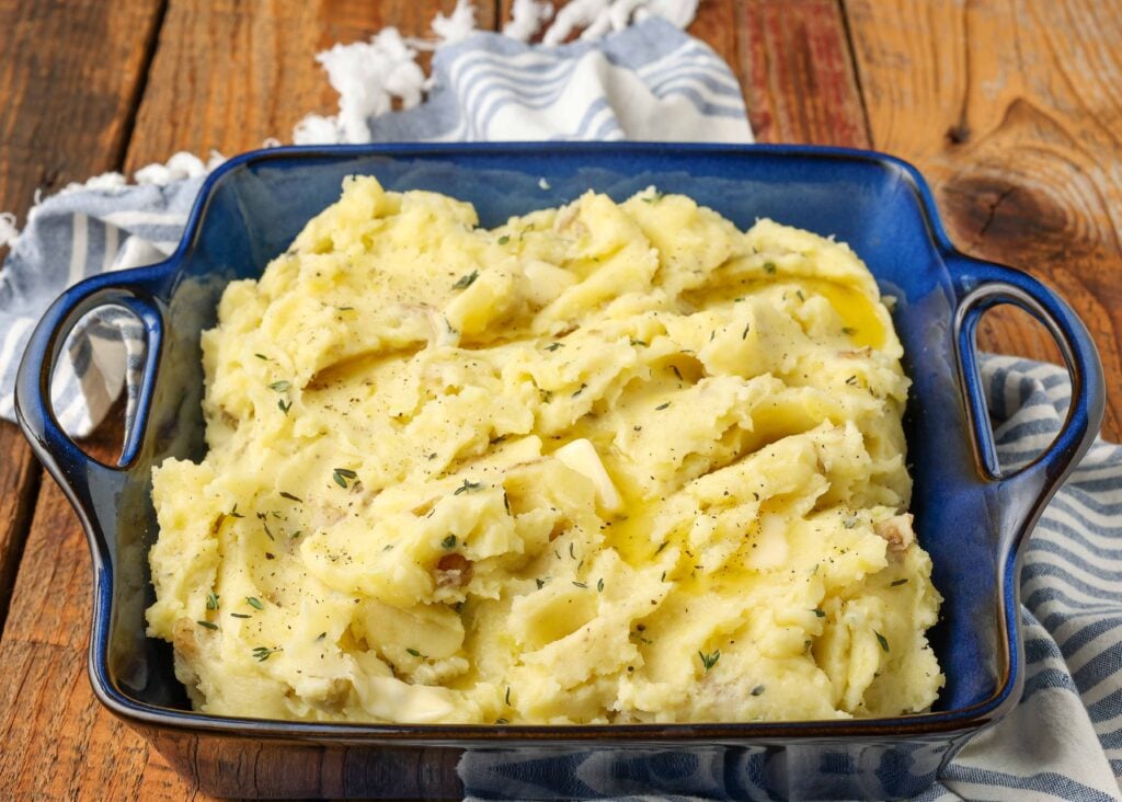 Horizontal shot of creamy thyme mashed potatoes in a blue serving dish