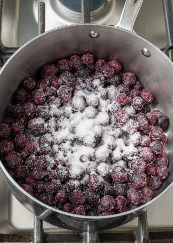 Blueberries and sugar in saucepan