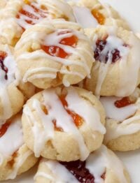 close up photo of thumbprint cookies with jam, drizzled with glaze