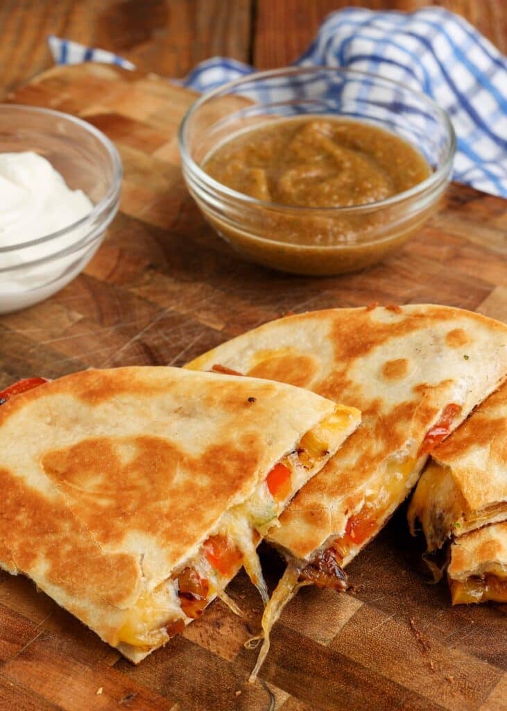 A quesadilla ready to eat with salsa visible in the background.