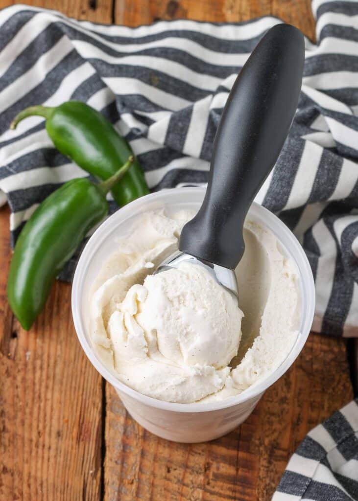 scoop ice cream in a container next to jalapenos