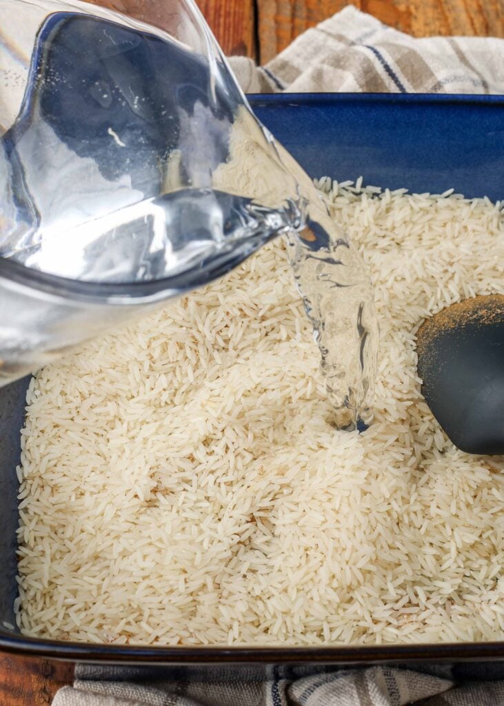 An action shot, pouring liquid over the seasoned rice.