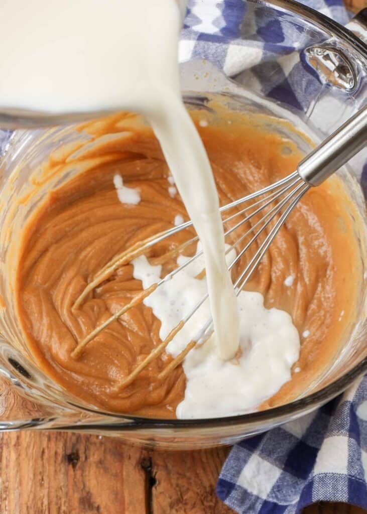 milk and cream being poured into melted cookie butter