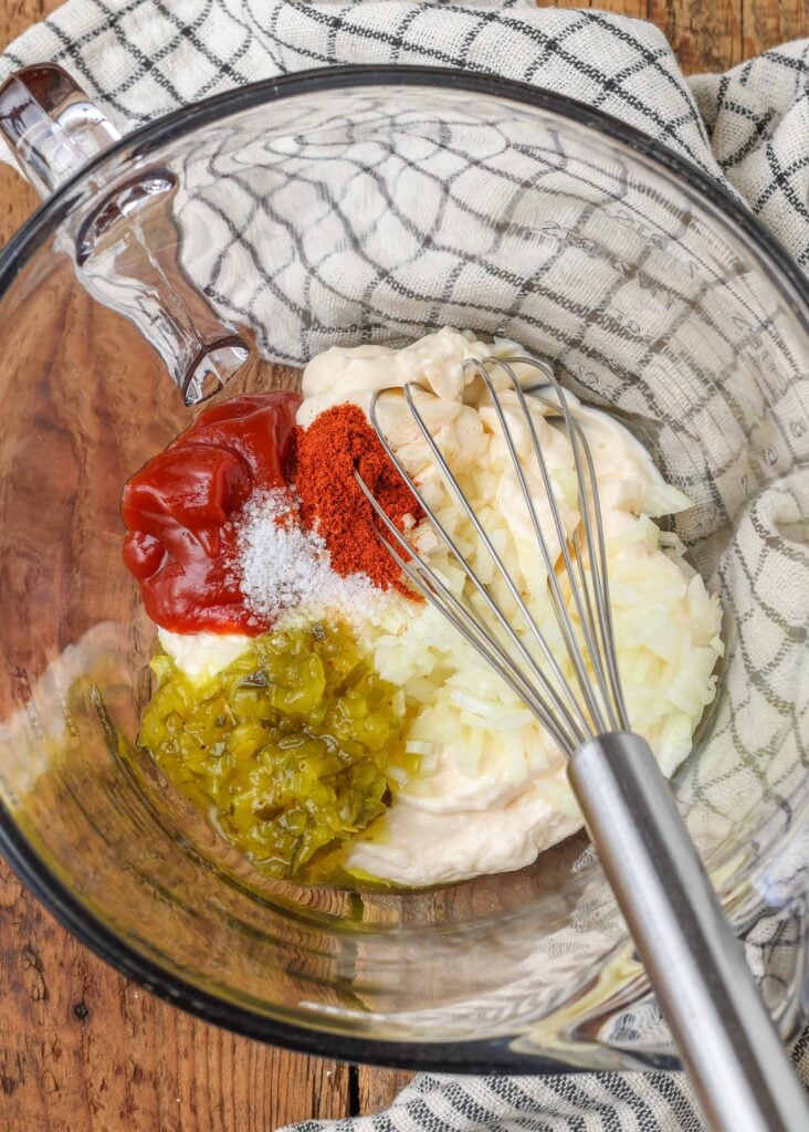 Mayonnaise, ketchup, onion, pickle relish, Worcestershire sauce, lemon juice, and salt combined in a glass bowl with whisk