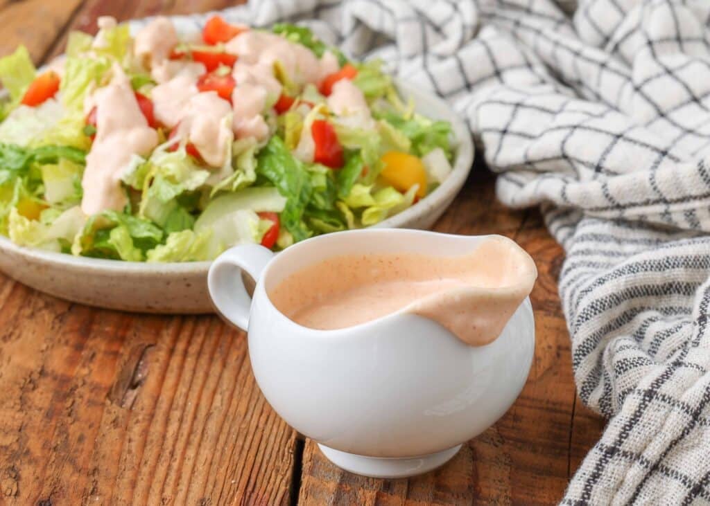Close up on small pitcher with sweet and savory salad dressing