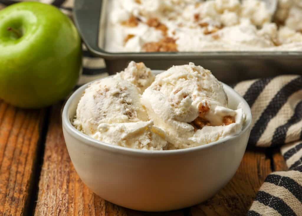 bowl of apple ice cream on wooden table with green apple in background