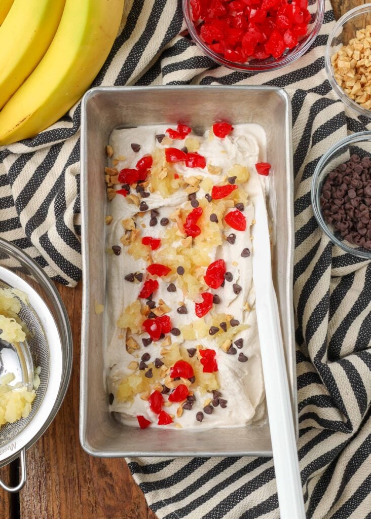 pan of freshly churned banana ice cream swirled with pineapple and cherries and chocolate chips