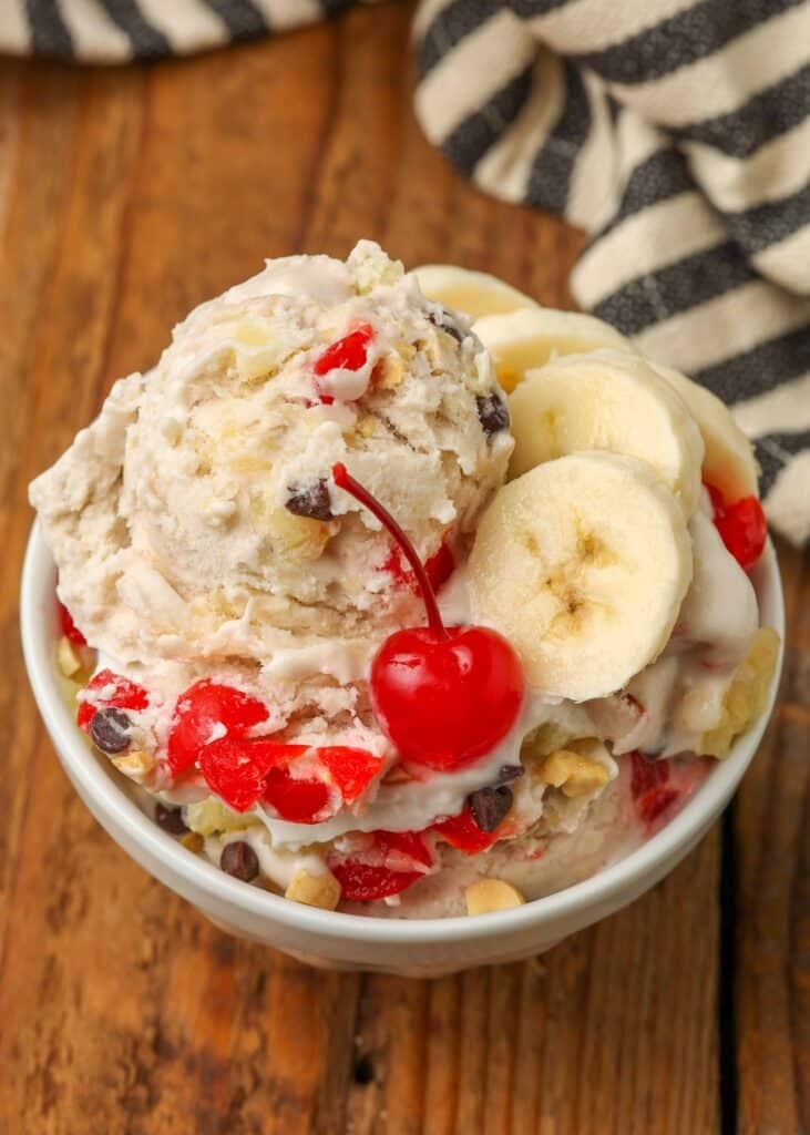 banana split ice cream scooped into bowls with a cherry on top