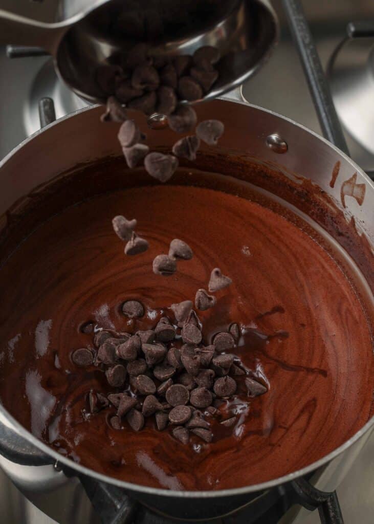 adding chocolate chips to saucepan