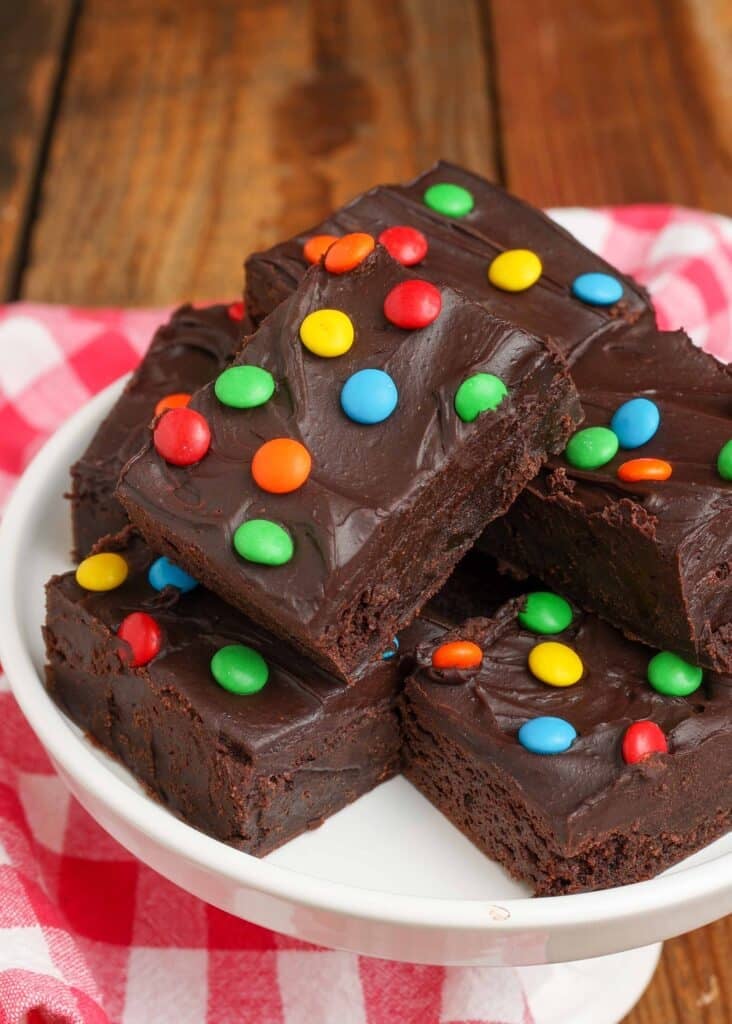 close up of frosted brownies stacked on plate