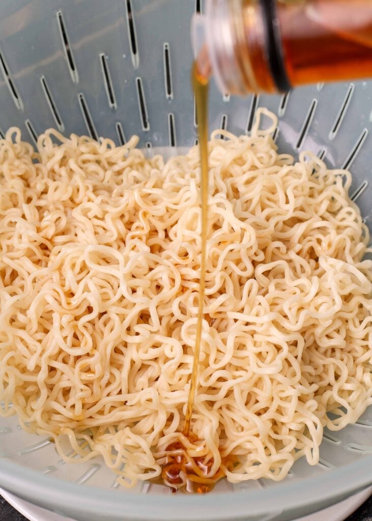 cooked ramen noodles in colander with sesame oil