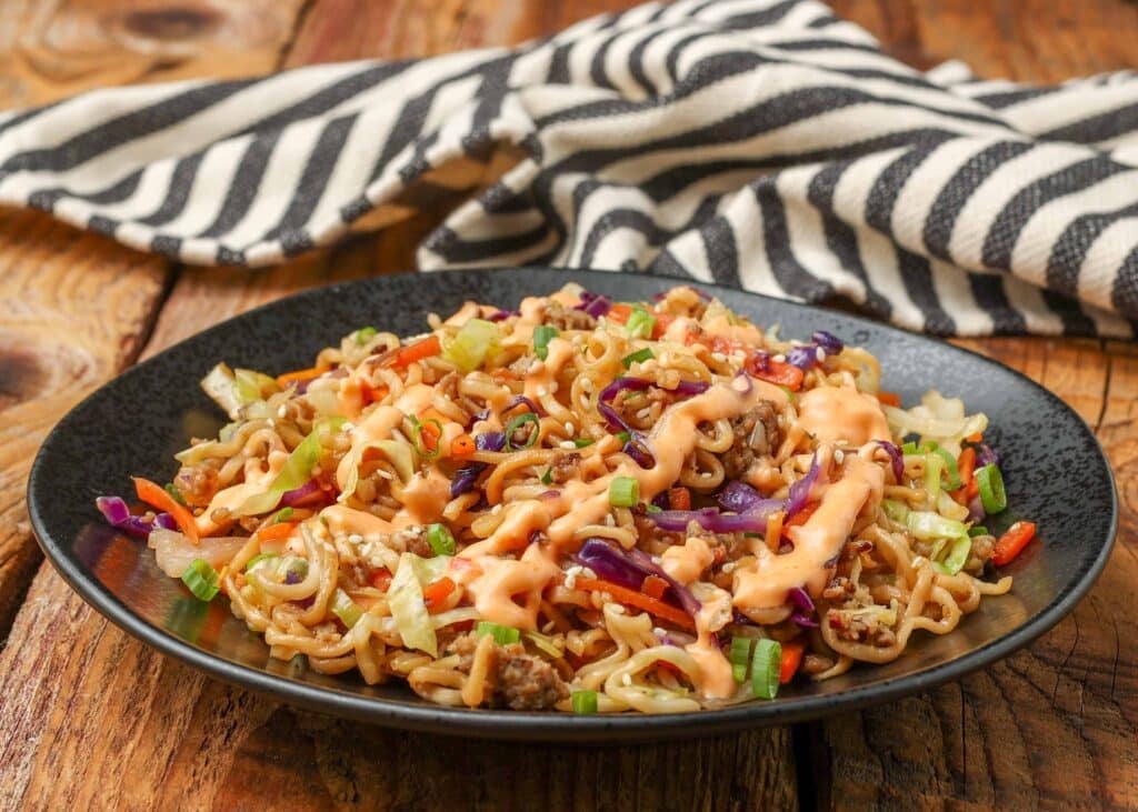 black plate holding stir fry with noodles 