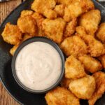 chicken chunks on black plate with bowl of blackened ranch dip