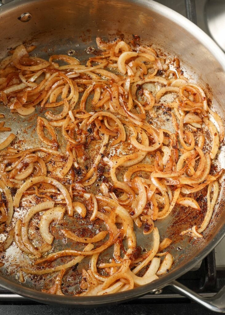 onions cooking in stainless skillet