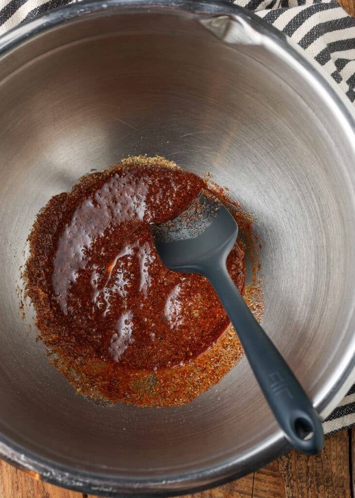 spices mixed together with oil in large stainless bowl with black spatula