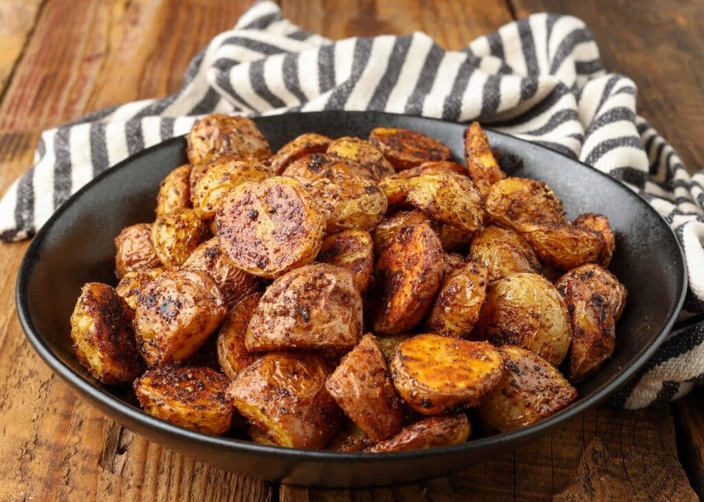 horizontal photo of roasted potatoes in bowl on wooden table